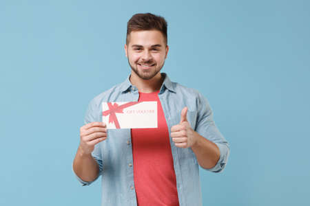 Smiling young bearded guy 20s in casual shirt posing isolated on pastel blue background studio...