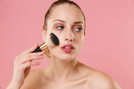 Close up blonde half naked woman 20s perfect skin nude make up blue eyes isolated on pastel pink wall background studio portrait. Skin care healthcare procedures concept. Mock up copy space Brush faceの写真素材