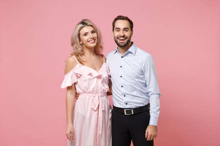Smiling young couple two guy girl in party outfit celebrating posing isolated on pastel pink background. People lifestyle Valentines Day, Womens Day birthday holiday party concept. Looking camera.の写真素材