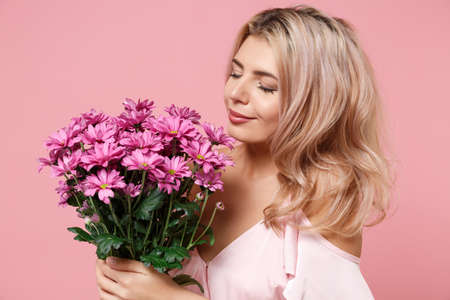 Young woman girl in party outfit celebrating posing isolated on pastel pink background. Valentines...