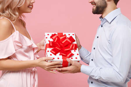 Cropped image of young couple two guy girl in party outfit celebrating isolated on pastel pink...