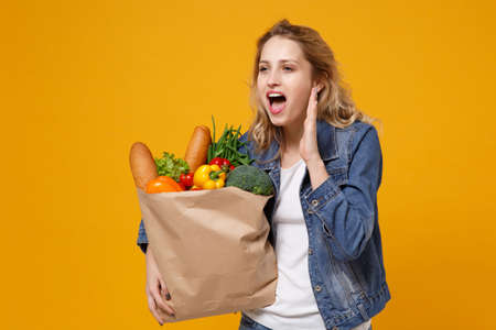 Woman in denim clothes isolated on orange background. Delivery service from shop or restaurant...