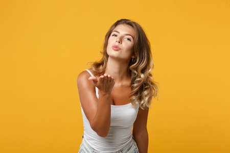 Pretty young woman girl in light casual clothes posing isolated on yellow orange background, studio...
