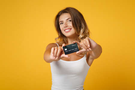 Attractive young woman girl in light casual clothes posing isolated on yellow orange wall...