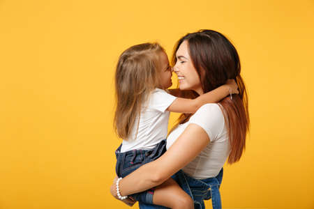 Woman in light clothes have fun with cute child baby girl 4-5 years old. Mommy little kid daughter isolated on yellow background studio portrait. Mothers Day love family parenthood childhood concept.の写真素材