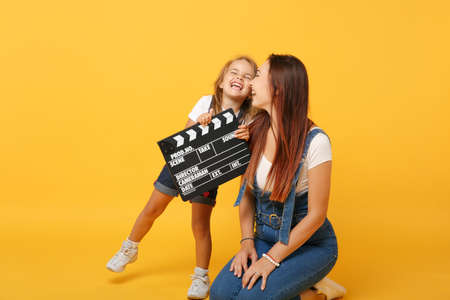 Woman in light clothes have fun with cute child baby girl 4-5 years old. Mommy little kid daughter isolated on yellow background studio portrait. Mothers Day love family parenthood childhood concept.の写真素材