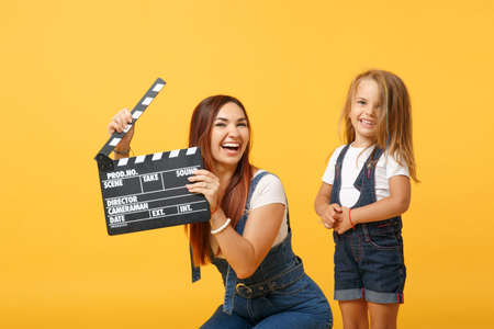 Woman in light clothes have fun with cute child baby girl 4-5 years old. Mommy little kid daughter isolated on yellow background studio portrait. Mothers Day love family parenthood childhood concept.の写真素材