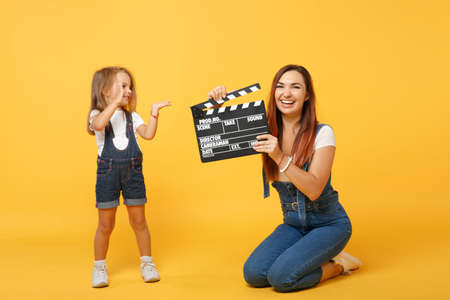 Woman in light clothes have fun with cute child baby girl 4-5 years old. Mommy little kid daughter isolated on yellow background studio portrait. Mothers Day love family parenthood childhood concept.の写真素材