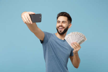 Young smiling man in casual clothes posing isolated on blue background. People lifestyle concept....