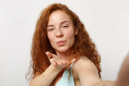 Close up Young pretty redhead woman girl in casual light clothes posing isolated on white wall...
