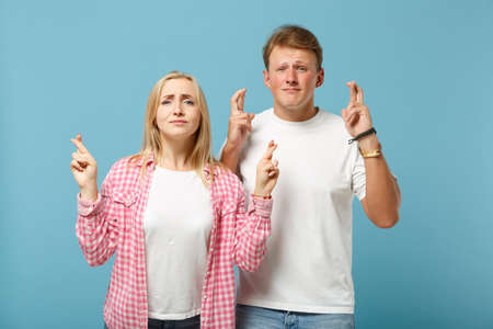 Young couple two friends guy girl in white pink t-shirts posing isolated on blue background. People...