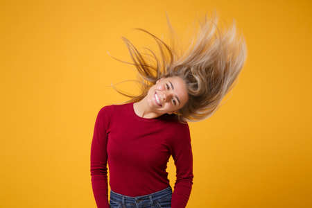 Smiling young blonde woman girl in casual clothes posing isolated on yellow wall orange background....