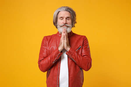 Elderly gray-haired mustache bearded man in red leather jacket isolated on yellow orange background....
