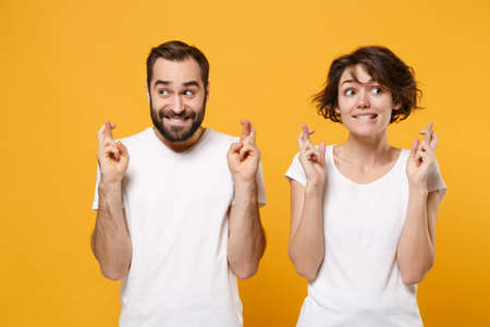 Young couple friends bearded guy girl in white t-shirts isolated on yellow orange background. People lifestyle concept.の写真素材