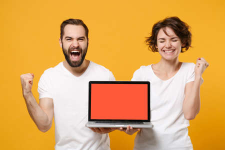 Happy couple friends bearded guy girl in white t-shirts isolated on yellow orange background.の写真素材