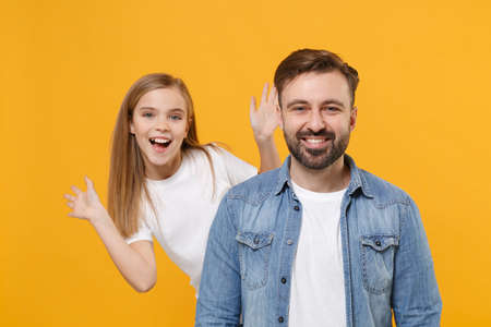 Cheerful bearded man in casual clothes have fun with cute child baby girl. Father little kid daughter isolated on yellow wall background. Love family day parenthood childhood concept. Spreading hands.の写真素材