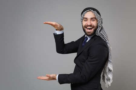 Arabian muslim businessman in keffiyeh kafiya ring igal agal classic black suit isolated on gray...