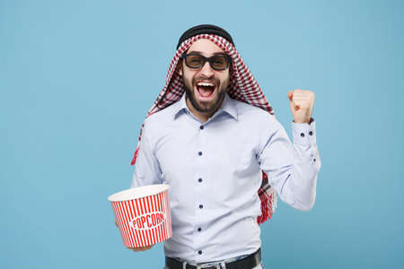 Happy arabian muslim man in keffiyeh kafiya ring igal agal 3d glasses isolated on pastel blue background.の写真素材