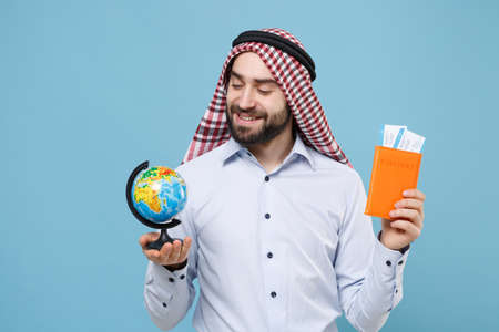 Smiling young bearded arabian muslim man in keffiyeh kafiya ring igal agal casual clothes isolated on pastel blue background.の写真素材