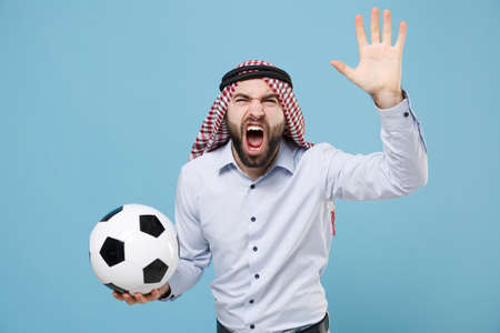 Angry young arabian muslim man in keffiyeh kafiya ring igal agal casual clothes isolated on pastel blue background.の写真素材