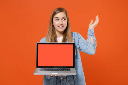 Beautiful young woman girl in casual denim clothes posing isolated on orange background.の写真素材