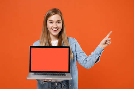 Funny young woman girl in casual denim clothes isolated on orange background.の写真素材