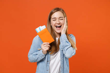 Excited young woman girl in denim clothes posing isolated on orange background.の写真素材