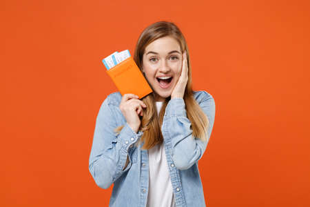 Excited young woman girl in casual denim clothes posing isolated on orange background in studio.の写真素材