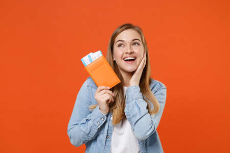 Pensive young woman girl in denim clothes posing isolated on orange background studio.の写真素材