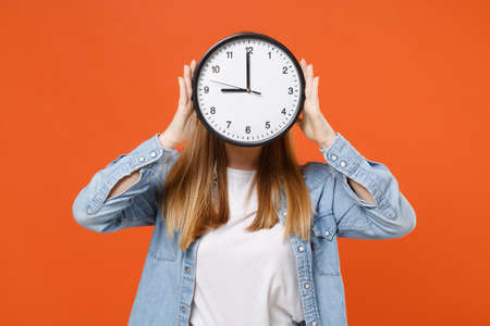 Young woman girl in casual denim clothes posing isolated on bright orange wall background studio portrait.の写真素材