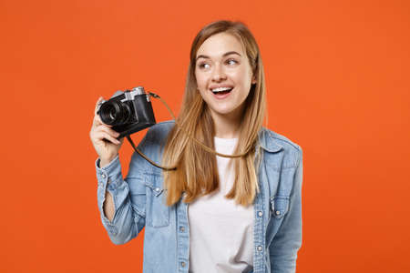Funny young woman girl in casual denim clothes posing isolated on orange background studio portrait.の写真素材