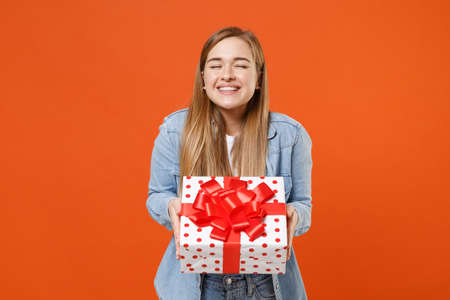 Smiling young woman girl in casual denim clothes isolated on orange background.の写真素材