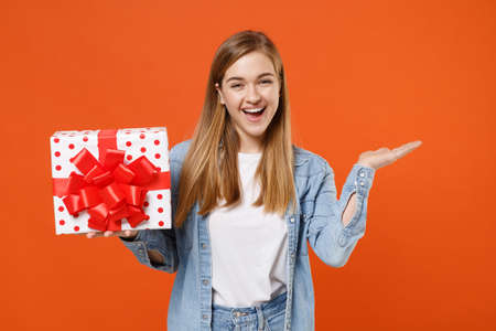 Funny young woman girl in casual denim clothes isolated on orange background.の写真素材