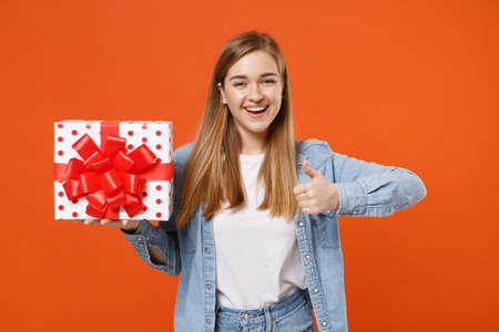 Cheerful young woman girl in casual denim clothes isolated on orange background.の写真素材