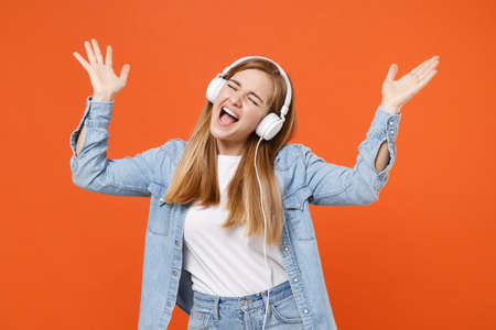 Funny young woman in denim clothes isolated on orange background. People lifestyle concept.の写真素材