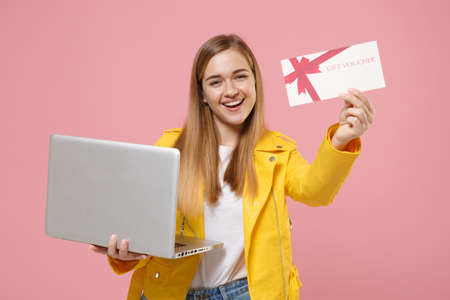 Cheerful young woman girl in yellow leather jacket posing isolated on pastel pink background studio...