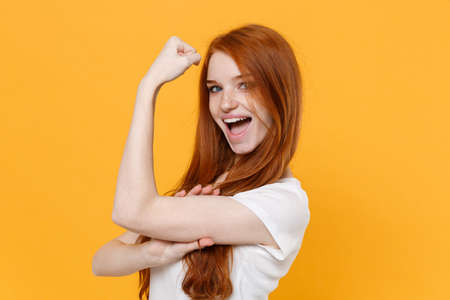 Side view of funny young redhead woman girl in white blank empty t-shirt posing isolated on yellow...