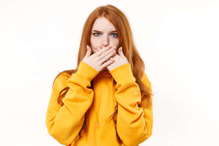 Shocked young redhead woman girl in casual yellow hoodie posing isolated on white background studio...