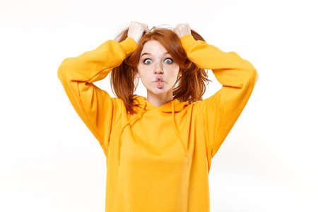 Funny young redhead woman girl in yellow hoodie posing isolated on white background. People...