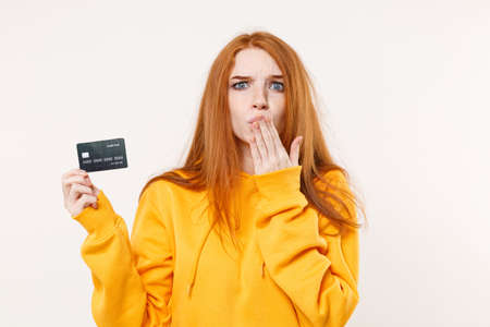Shocked young redhead woman girl in casual yellow hoodie posing isolated on white background in...