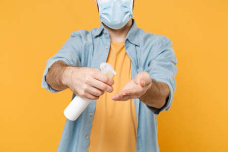 Cropped image of young man in face mask isolated on yellow background. Epidemic pandemic coronavirus...