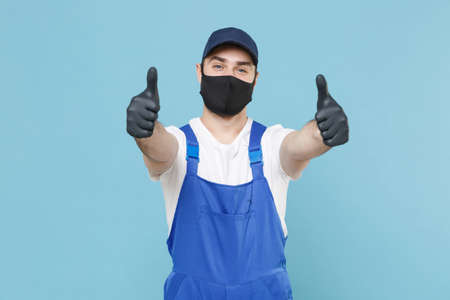 Delivery man in cap t-shirt coveralls uniform sterile face mask gloves isolated on blue background...