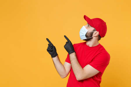 Delivery man in red cap blank t-shirt uniform sterile face mask gloves isolated on yellow background...