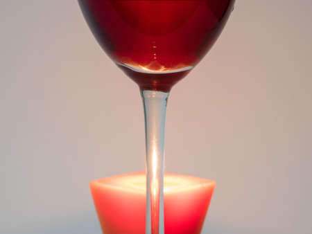 Fire candle through the leg with a glass of red wineの写真素材