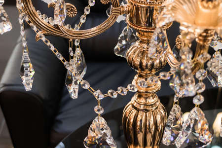 Rich interior - lxurious gilded floor lamp on the background of a black leather chairの写真素材