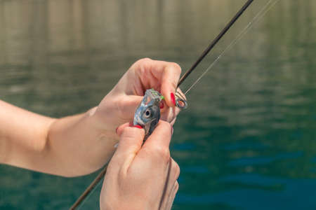 Girl is fishing in the sea bay on fish-rodの写真素材