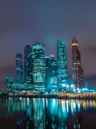Business district of the Moscow in colorful night lights. The roofs of the buildings in the fog, and around the sky beautiful shades.の写真素材