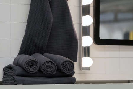 Black towels in the bathroom near the mirror.の写真素材