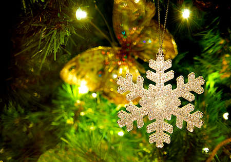 Snowflake ornament hanging from a Christmas tree.の写真素材