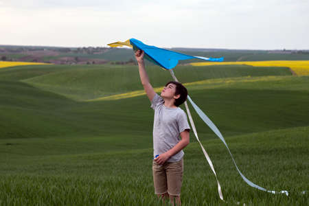 Ukrainian teenage boy holding a yellow-blue kite in his handsの写真素材